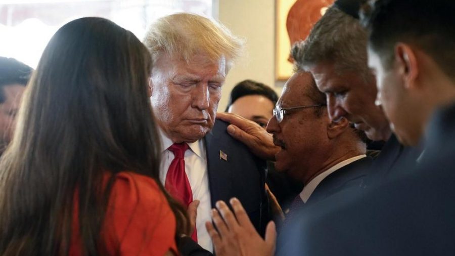 Former President Donald Trump prays with pastor Mario Bramnick, third from right, and others at Versailles restaurant on Tuesday, June 13, 2023, in Miami.