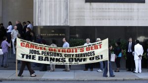 Protesters carry a sign outside the Levin Federal Courthouse in Detroit, Wednesday, July 24, 2013.