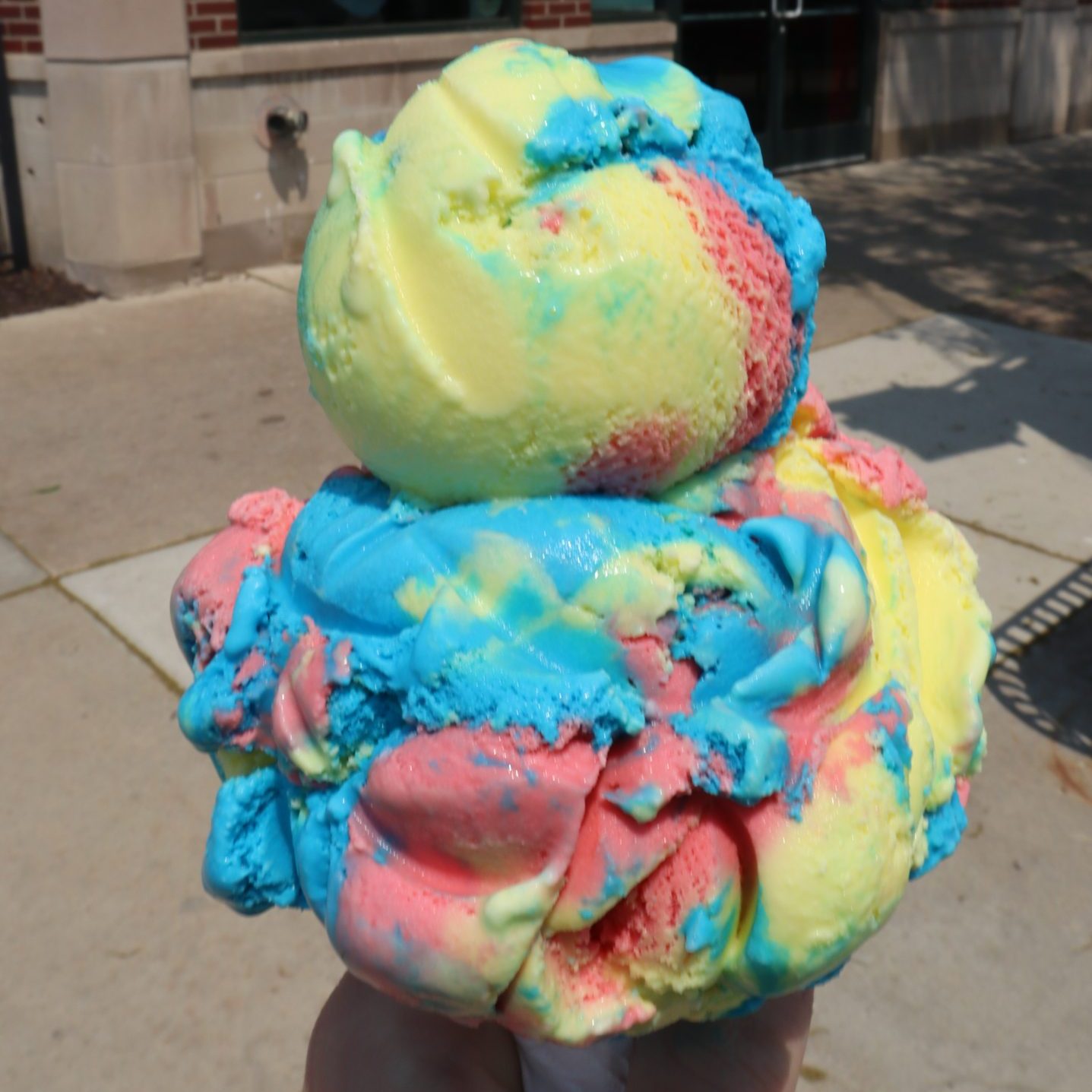 Someone holds a cone of Superman-flavored ice cream