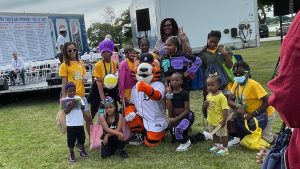 Children gather around Detroit Tigers mascot Paws to pose for a photo Metro Detroit Youth Day on July 12, 2023, on Belle Isle.