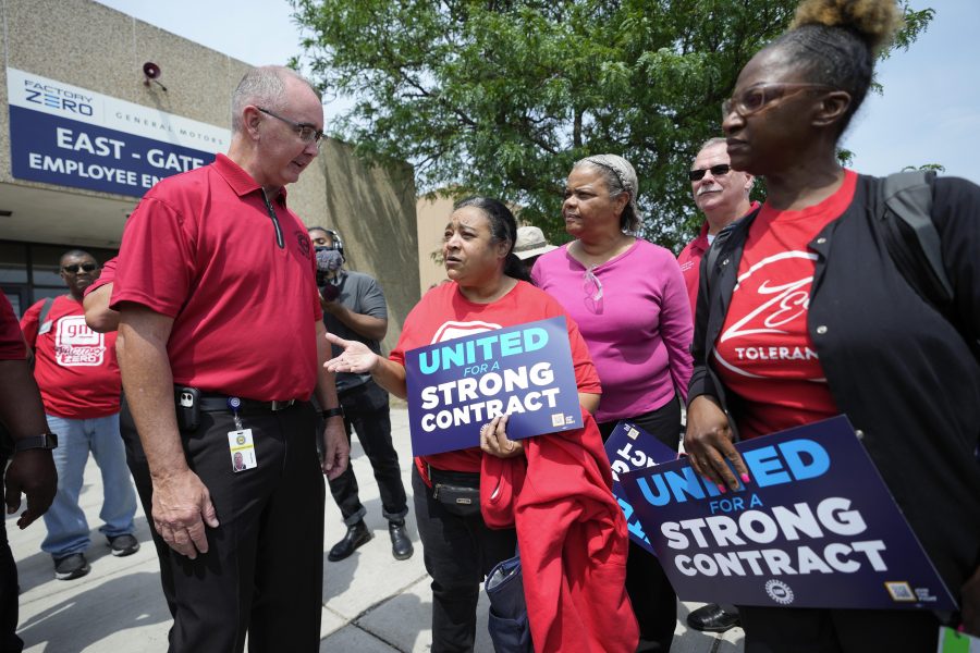 United Auto Workers president Shawn Fain, left, talks with autoworkers outside the General Motors Factory Zero plant in Hamtramck, Mich., Wednesday, July 12, 2023.