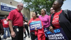 United Auto Workers president Shawn Fain, left, talks with autoworkers outside the General Motors Factory Zero plant in Hamtramck, Mich., Wednesday, July 12, 2023.