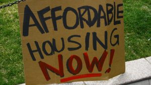 A sign that says "affordable housing now."