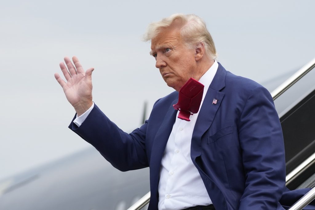 FILE - Former President Donald Trump waves as he steps off his plane at Ronald Reagan Washington National Airport, Aug. 3, 2023, in Arlington, Va.