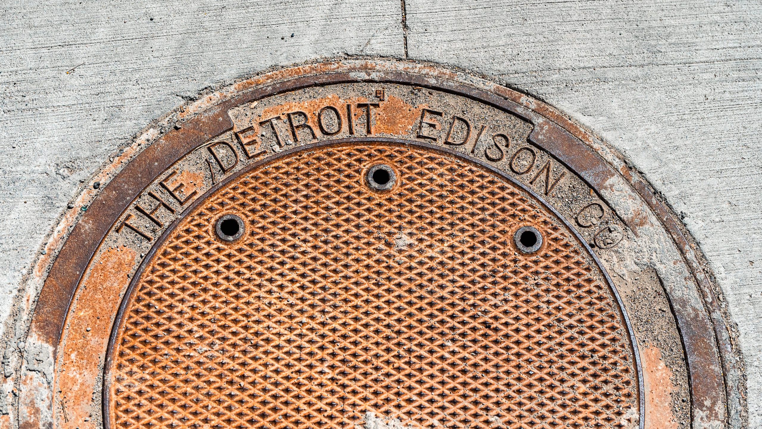 Manhole cover bearing the name of DTE Energy's previous identity the Detroit Edison Company.