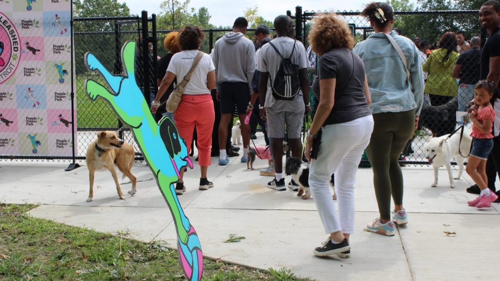 A crowd of people and their dogs squeeze into Palmer Park dog park during the grand opening.
