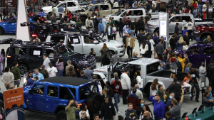 A floor crowded with people and cars at a past North American International Auto Show in Detroit. (Courtesy of NAIAS)
