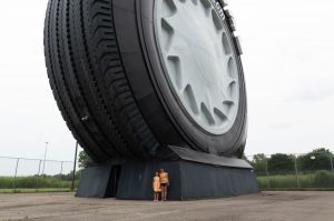 Valerie Brenner and her daughter Annika pose by the Giant Tire, dwarfed by its size.