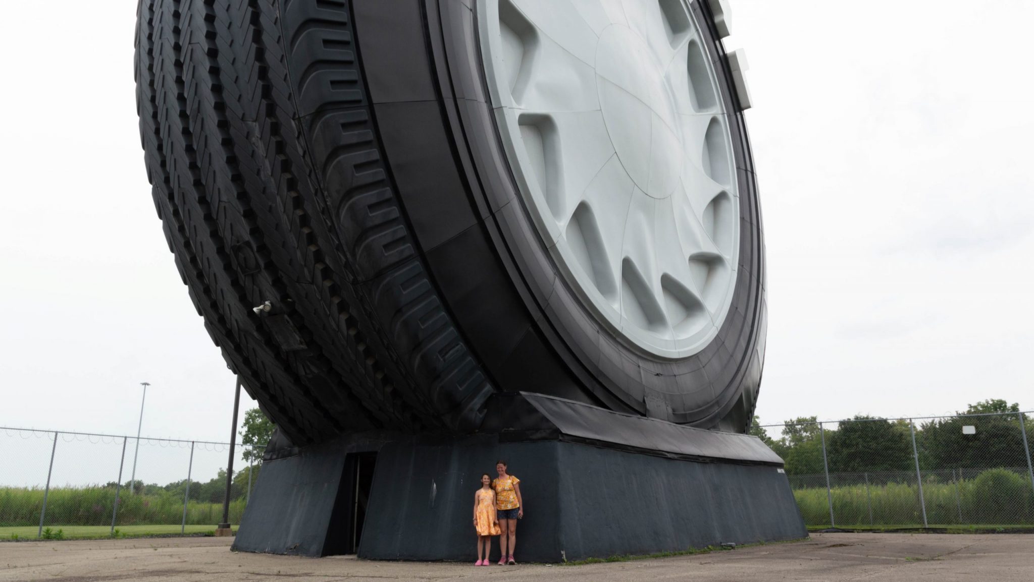Valerie Brenner and her daughter Annika pose by the Giant Tire, dwarfed by its size.