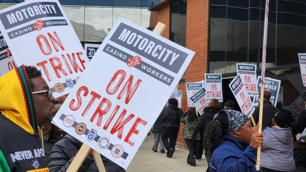 Striking workers wave their signs in the air.