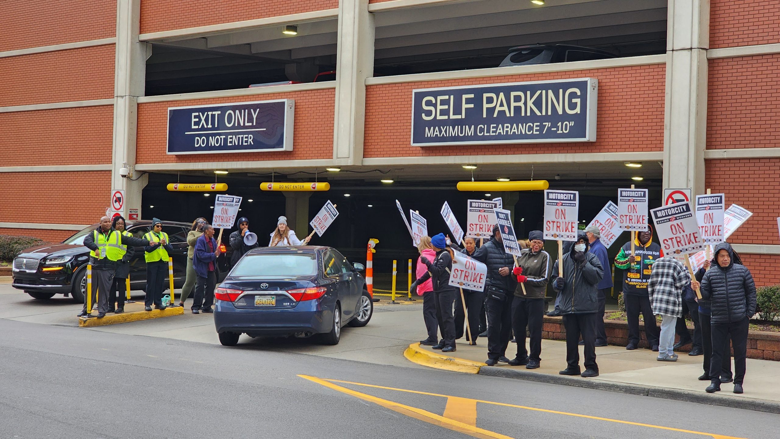 Picketing casino workers heckle cars as they enter a MotorCity Casino parking deck.