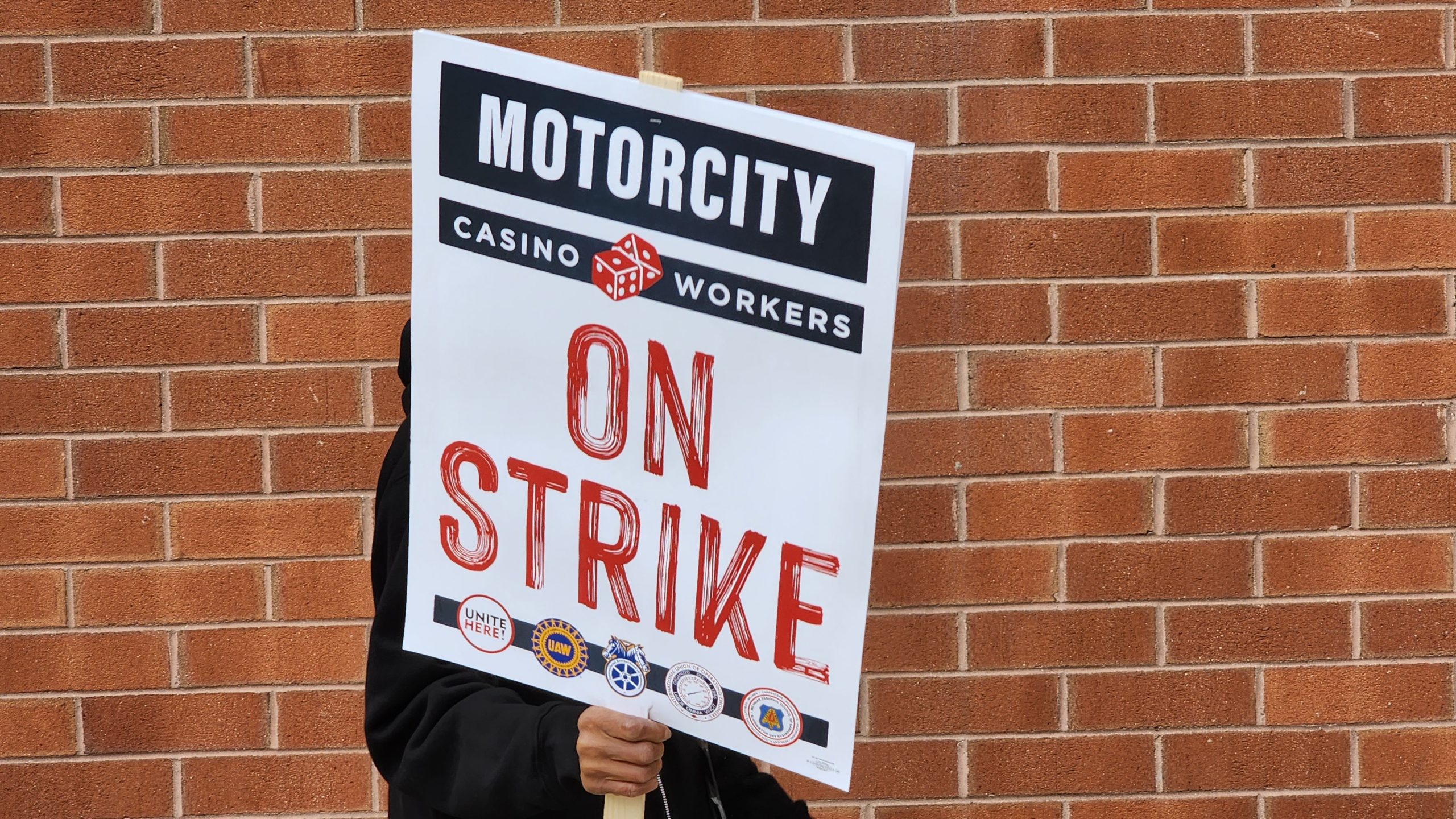 A casino worker marches with a picket sign.