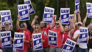 United Auto Workers members hold picket signs near a General Motors Assembly Plant in Delta Township, Mich., Friday, Sept. 29, 2023.