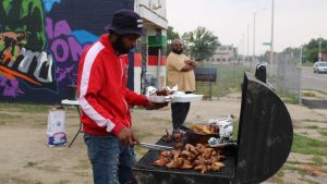 Mario Timmons (left) and Frederick Lamar grill chicken wings at their pop-up on Dexter Avenue in Detroit.