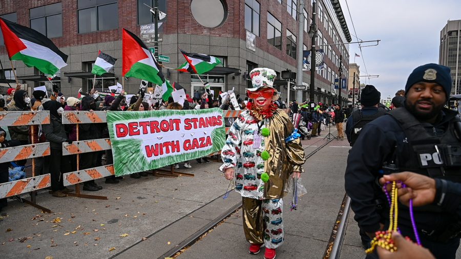 A clown in Detroit's Thanksgiving Day Parade passes by pro-Palestinian protesters.
