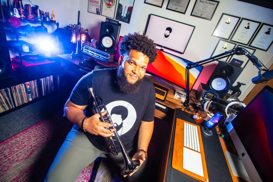Kris Johnson holds hi trumpet in his home studio space