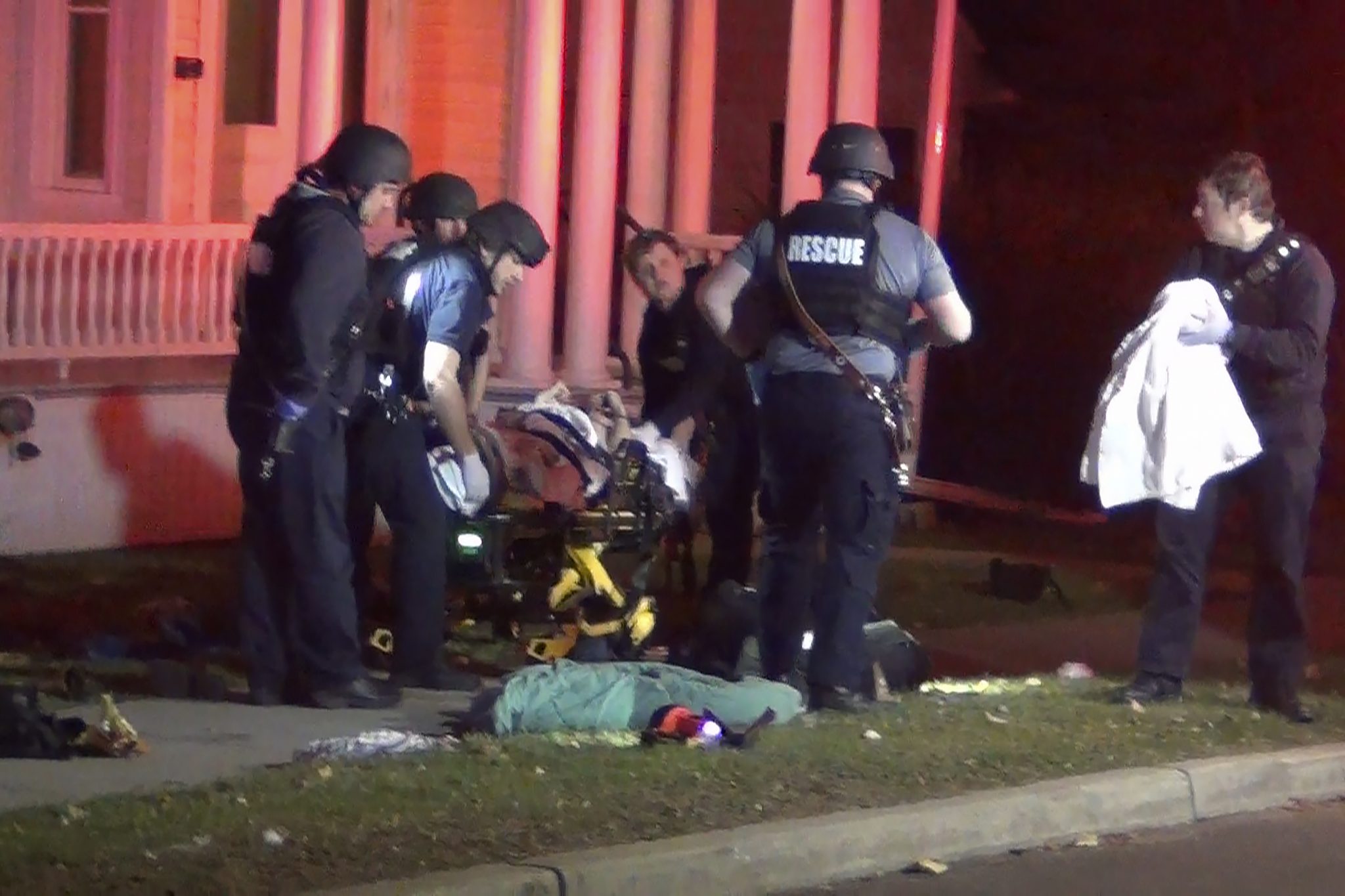 In a still frame from video first responders use a gurney to remove an injured man from the scene of a shooting, Saturday, Nov. 25, 2023, in Burlington, Vt.