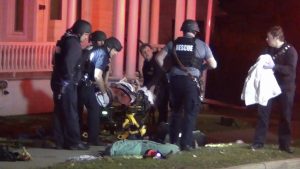 In a still frame from video first responders use a gurney to remove an injured man from the scene of a shooting, Saturday, Nov. 25, 2023, in Burlington, Vt.