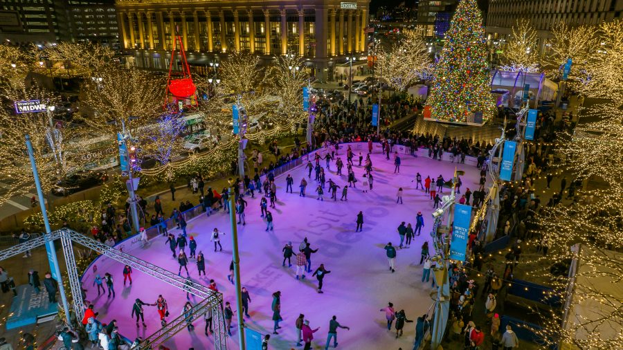 A crowded ice rink in Detroit illuminated by lit-up trees and purple lights
