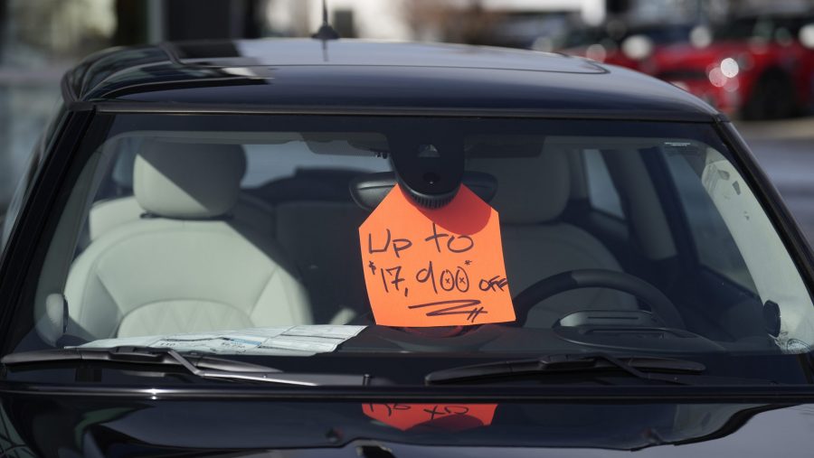 A sign noting the available discount available to buyers stands inside an unsold 2024 Cooper SE electric hardtop outside a Mini dealership on Thursday, Nov. 30, 2023, in Loveland, Colo.