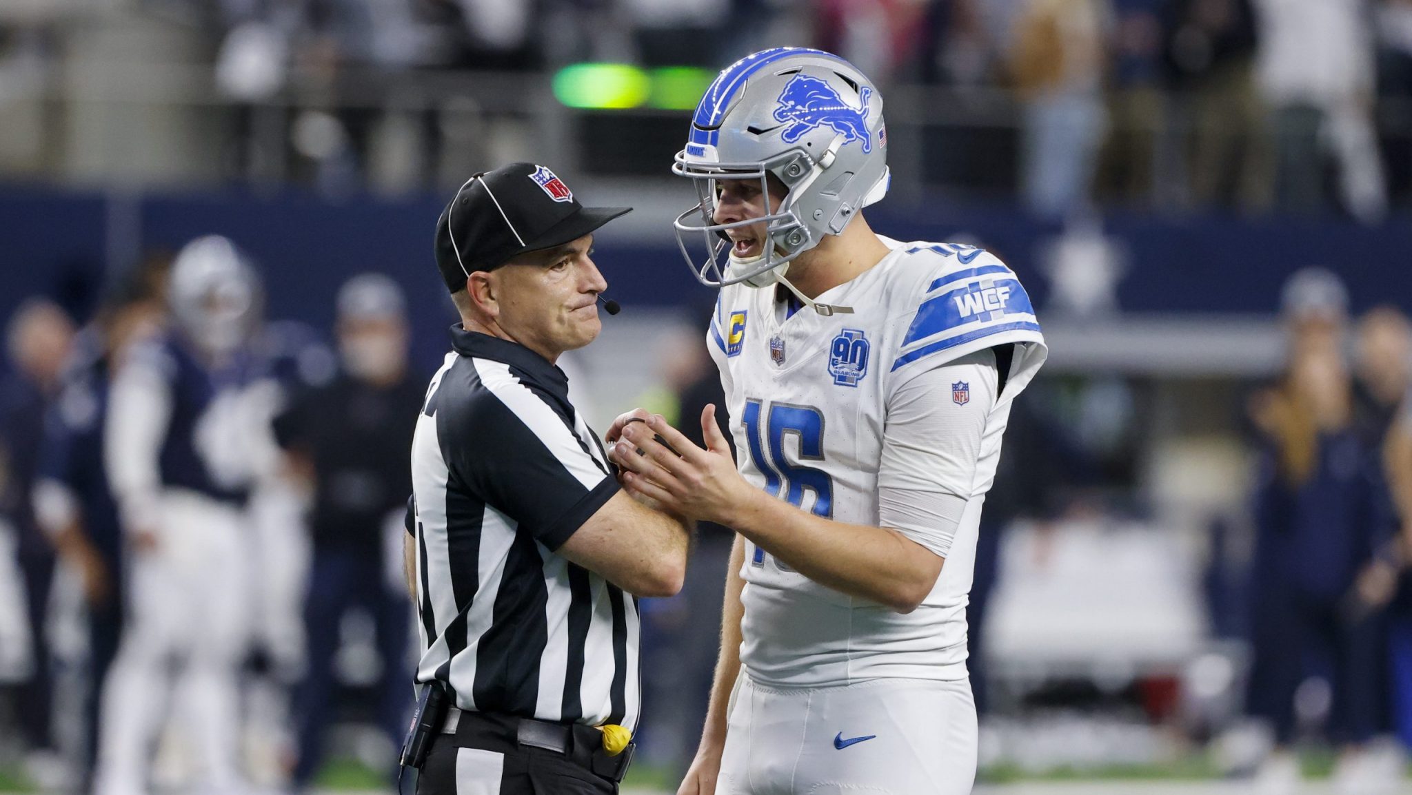 Detroit Lions quarterback Jared Goff (16) talks with umpire Duane Heydt after a 2-point conversion play by the Lions against the Dallas Cowboys in the second half of an NFL football game, Saturday, Dec. 30, 2023, in Arlington, Texas. The Cowboys won 20-19. (AP Photo/Michael Ainsworth)