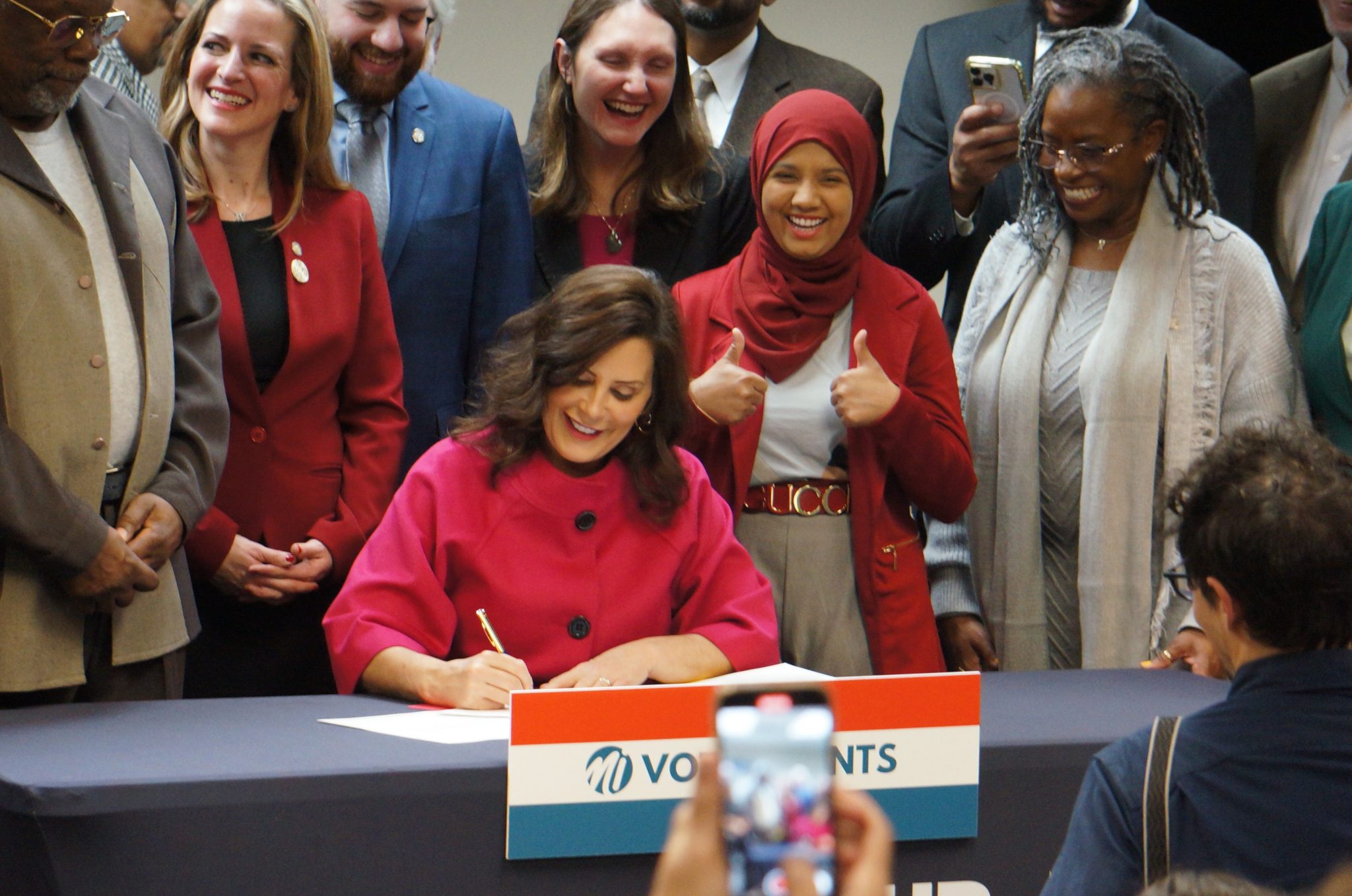 Gov. Gretchen Whitmer signs one of 23 bills to expand voting rights in Michigan. One of the new laws requires campaign ads to indicate if they make substantial use of AI technology.