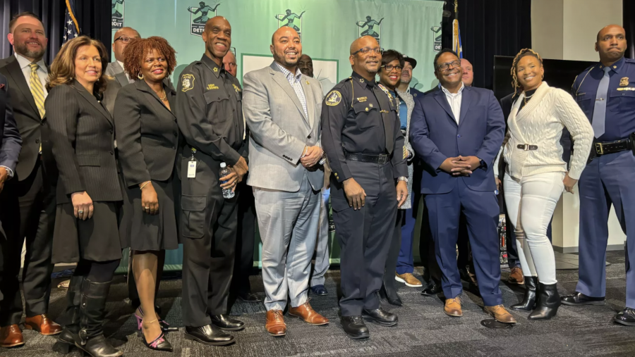 State, federal and local partners, including Alia Harvey-Quinn from FORCE Detroit, pose with Detroit Police Chief James White at a press conference announcing a drop in violent crime in 2023.