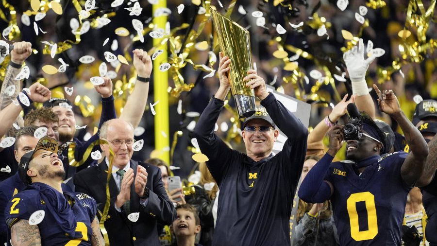 Michigan head coach Jim Harbaugh celebrates with the trophy after their win in the national championship NCAA College Football Playoff game against Washington Monday, Jan. 8, 2024, in Houston.