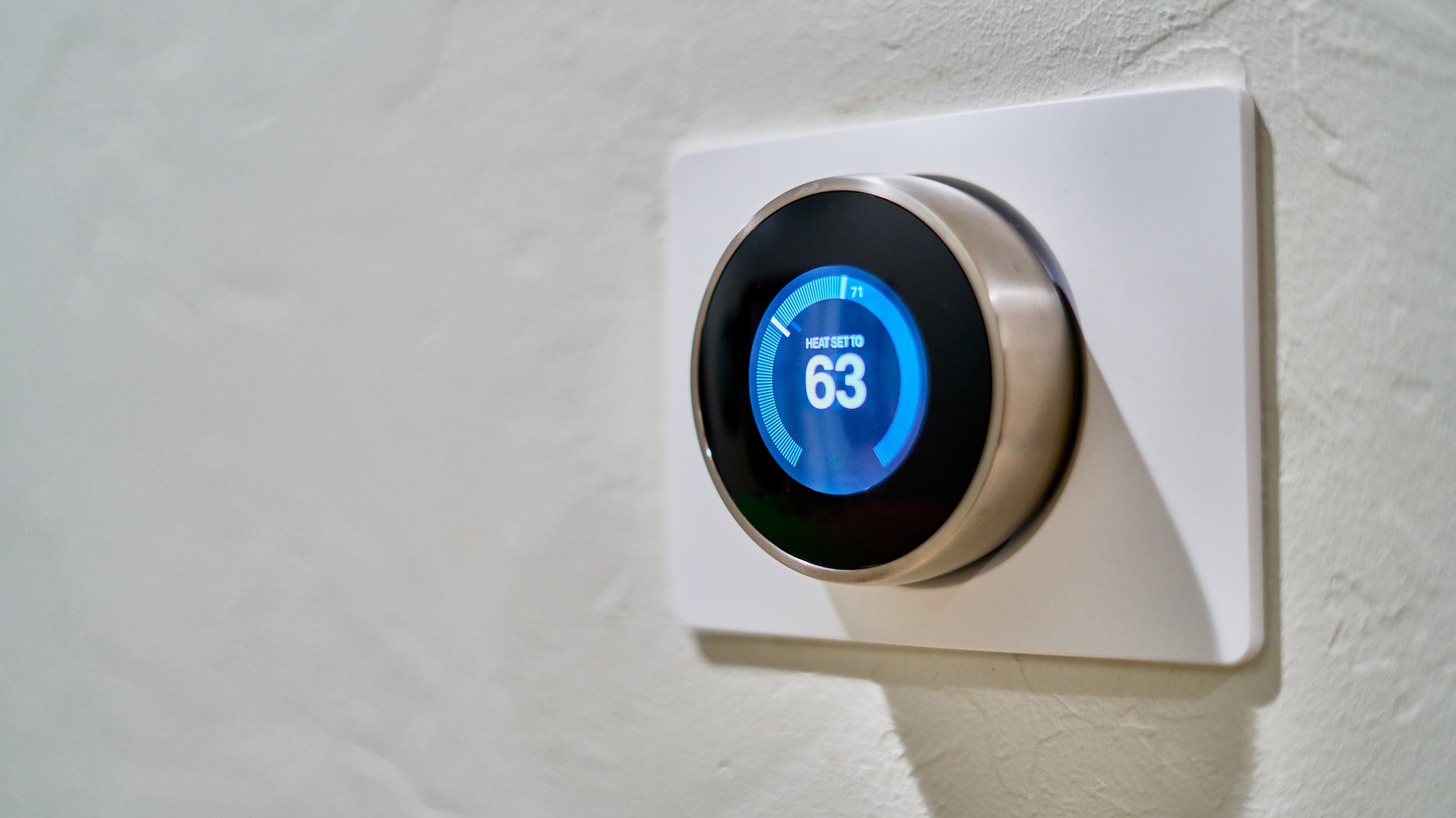 A stock image of a thermostat mounted on a wall.