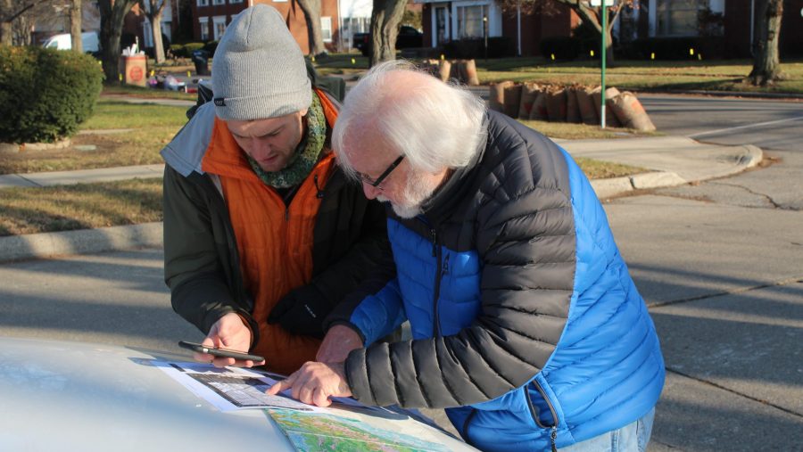 Mike Wilczynski, a retired geologist, and Koby Levin, reporter for Outlier Media, look at a topographical map as they search for the highest natural point in Detroit.