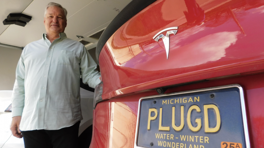 Bruce Westlake standing next to the two electric vehicles in his garage.