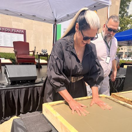 Ann Delisi places her hand prints in cement during Concert of Colors 2023 in Detroit.