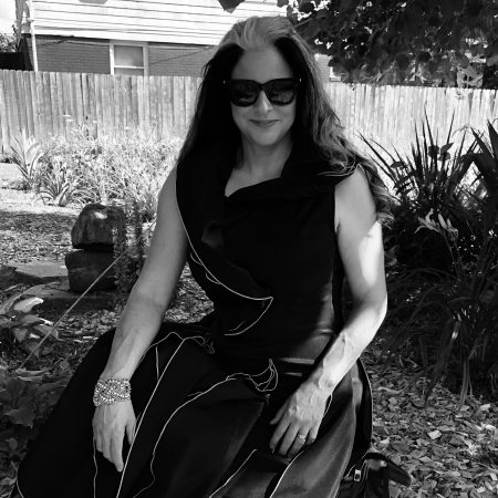 Ann Delisi wearing sunglasses and a black dress.