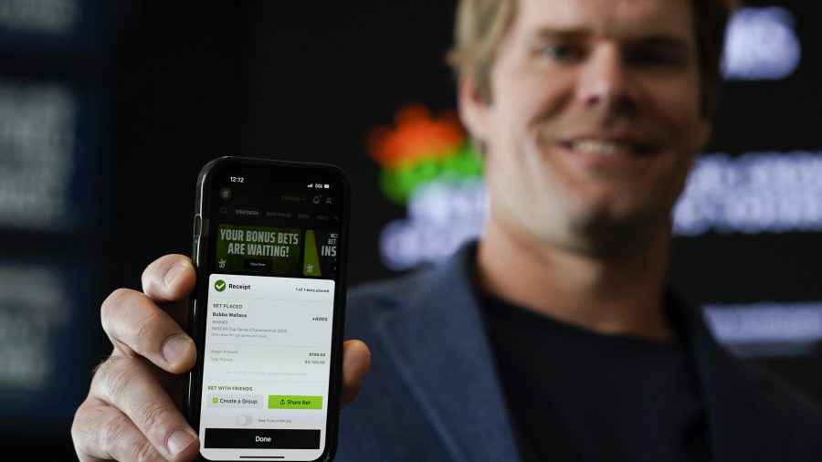 FILE - Fox Sports broadcaster Greg Olsen, who placed the first ceremonial bet in North Carolina, shows his receipt during a DraftKings event celebrating the launch of mobile and online sports wagering across the state at the NASCAR Hall of Fame, March 11, 2024, in Charlotte, N.C.