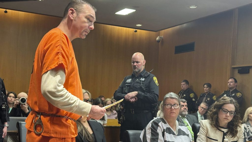 Defendant James Crumbley speaks before his sentencing for involuntary manslaughter in a school shooting committed by his son, Tuesday, April 9, 2024, in Pontiac, Mich. His wife, Jennifer Crumbley, center, listens. The Crumbleys were each sentenced to at least 10 years in prison Tuesday for failing to take steps that could have prevented the killing of four students in 2021.