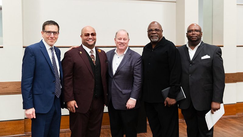 University of Michigan Professor Jeffrey Morenoff (left) stands with Detroit Mayor Mike Duggan (center) and other speakers at a press conference on April 16, 2024, about Morenoff’s findings on how Detroit home values changed from 2014 to 2022.