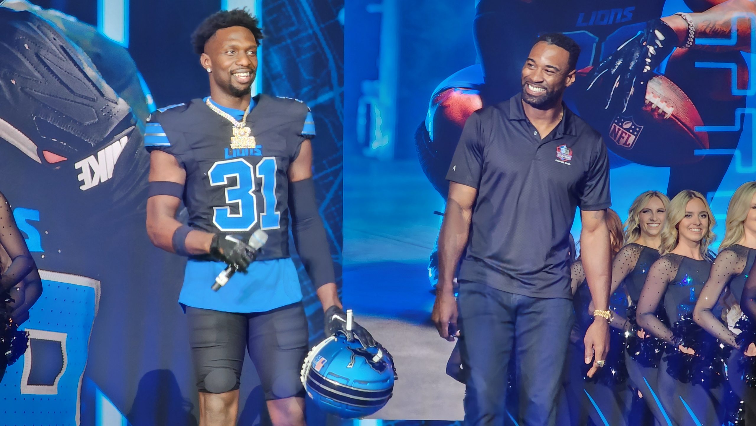 Detroit Lions safety Kerby Joseph (left) shows off the team's new alternate black uniform joined by former Lions wide receiver Calvin Johnson.