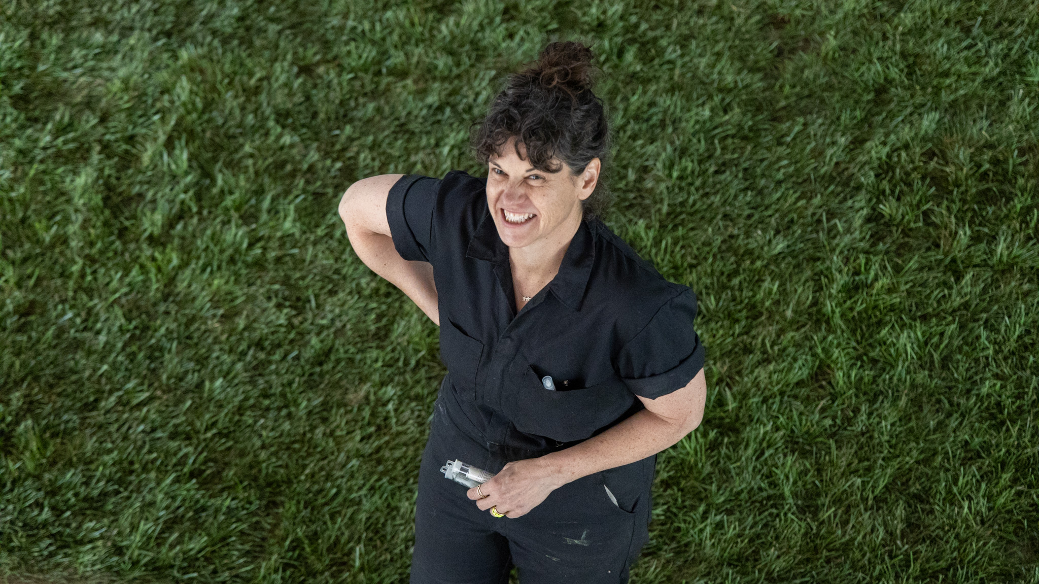 Artist Lisa Waud poses on the grass set inside the Boyer Campbell Building in Detroit for her Petrichor botanical art installation on May 30, 2024. (Photo credit: Tayler Simpson, WDET)