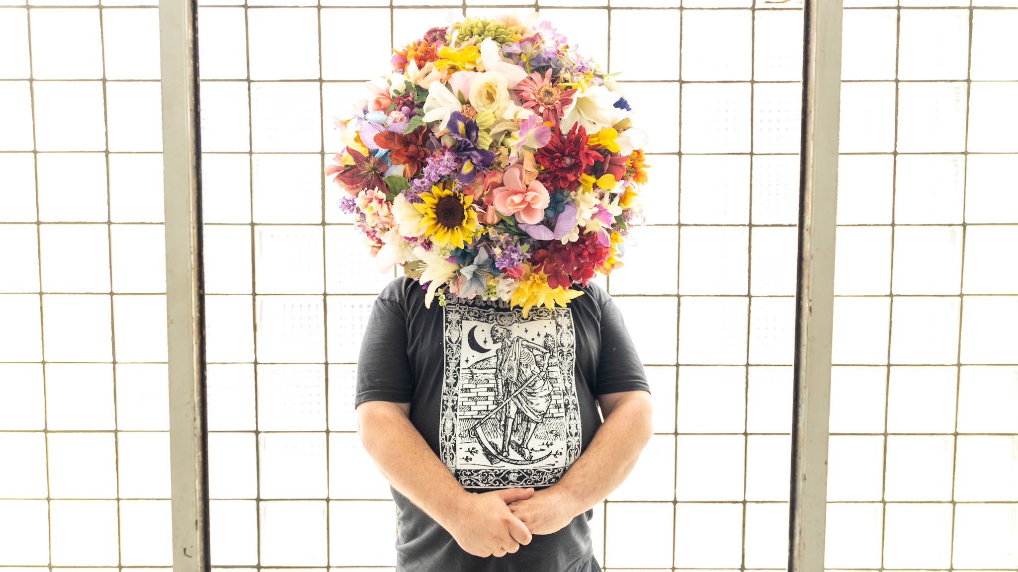 WDET host Ryan Patrick Hooper wearing a flower headdress created by artist Lisa Waud.