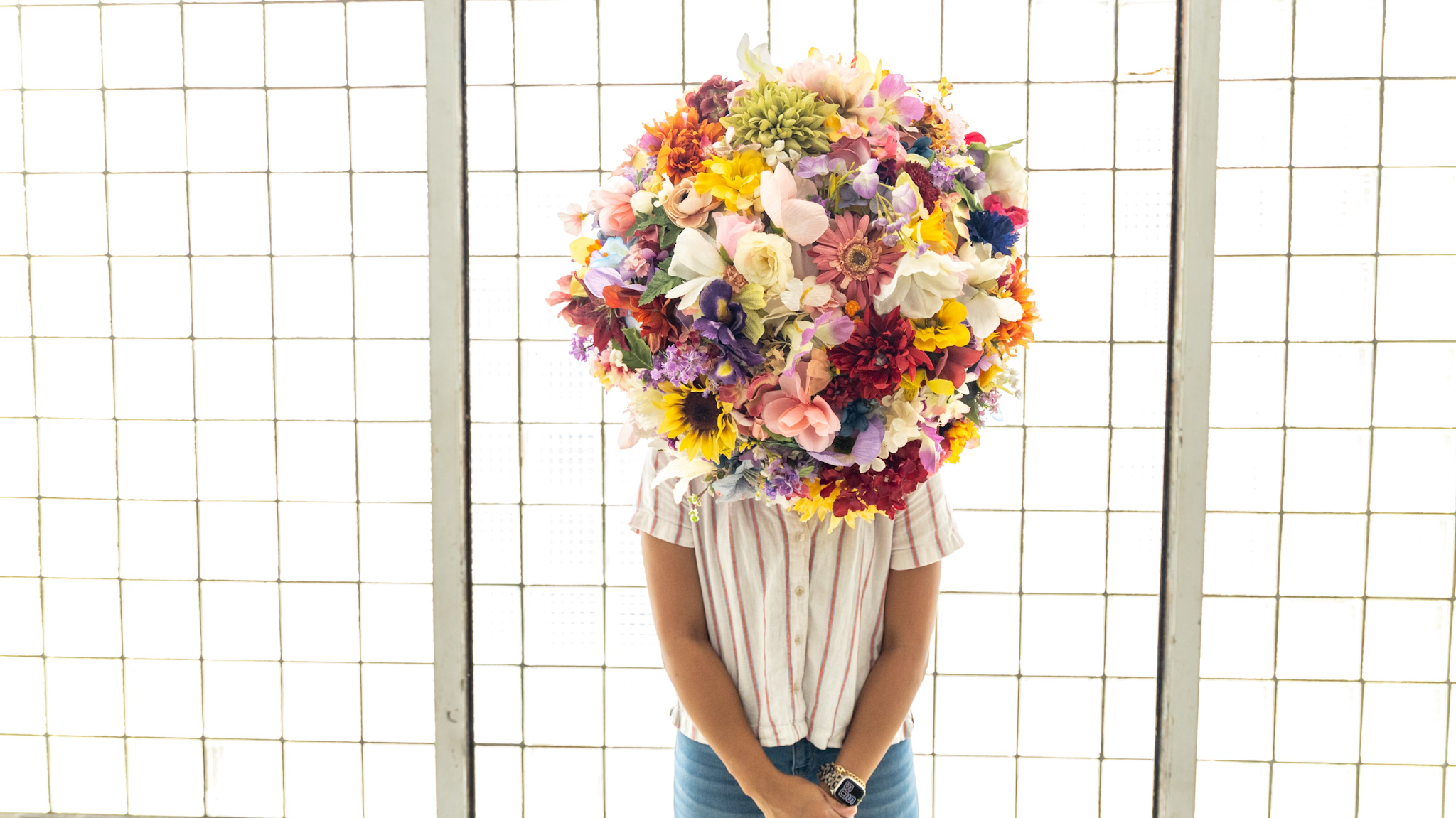 WDET photojournalist intern Tayler Simpson wears a flower headdress created by artist Lisa Waud.
