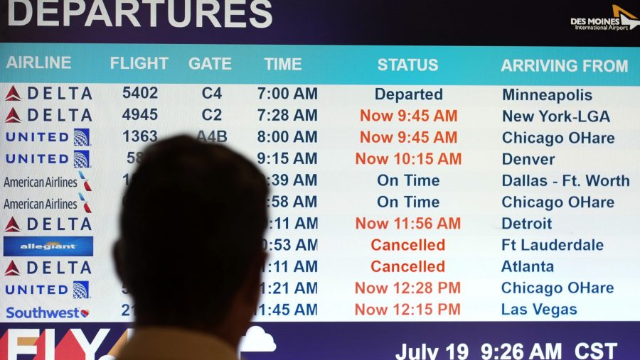 A passenger looks at a departures monitor at the Des Moines International Airport, Friday, July 19, 2024, in Des Moines, Iowa.
