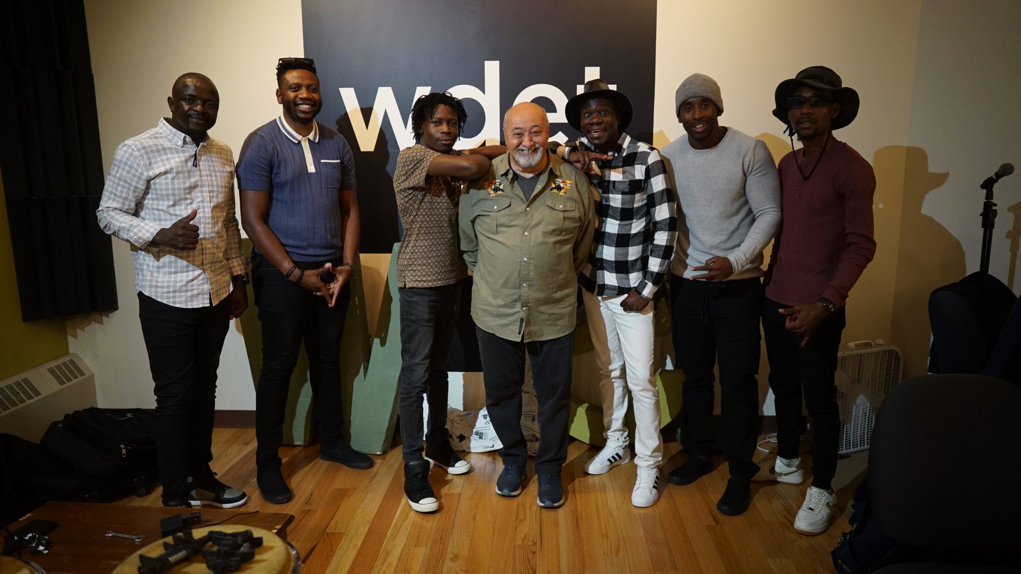 WDET "This Island Earth" host Ismael Ahmed posing with members of Mokoomba inside the WDET studios.