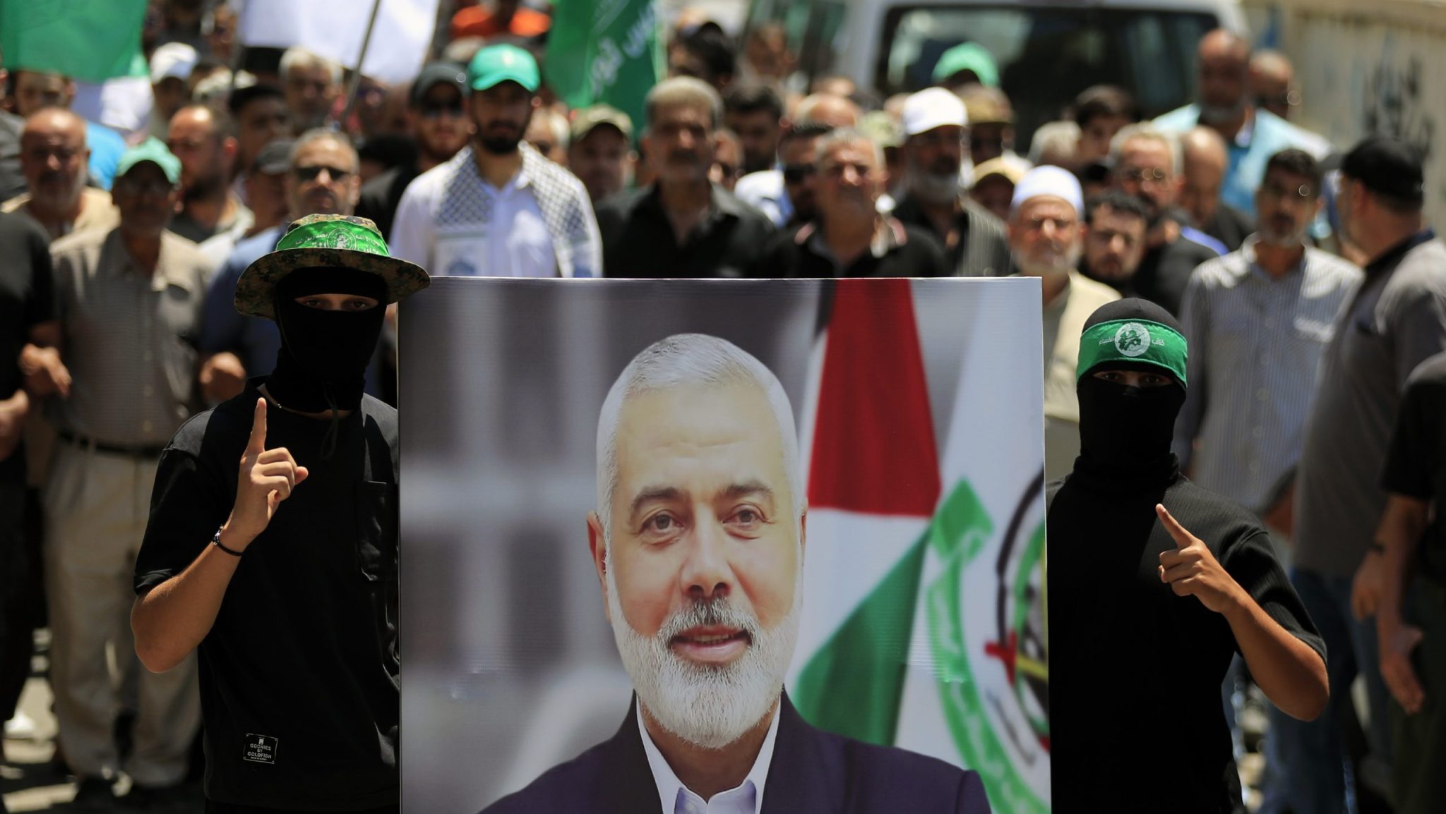 Hamas members hold a poster of Hamas political chief Ismail Haniyeh during a protest to condemn his killing, at al-Bass Palestinian refugee camp, in the southern port city of Tyre, Lebanon, Wednesday, July 31, 2024.