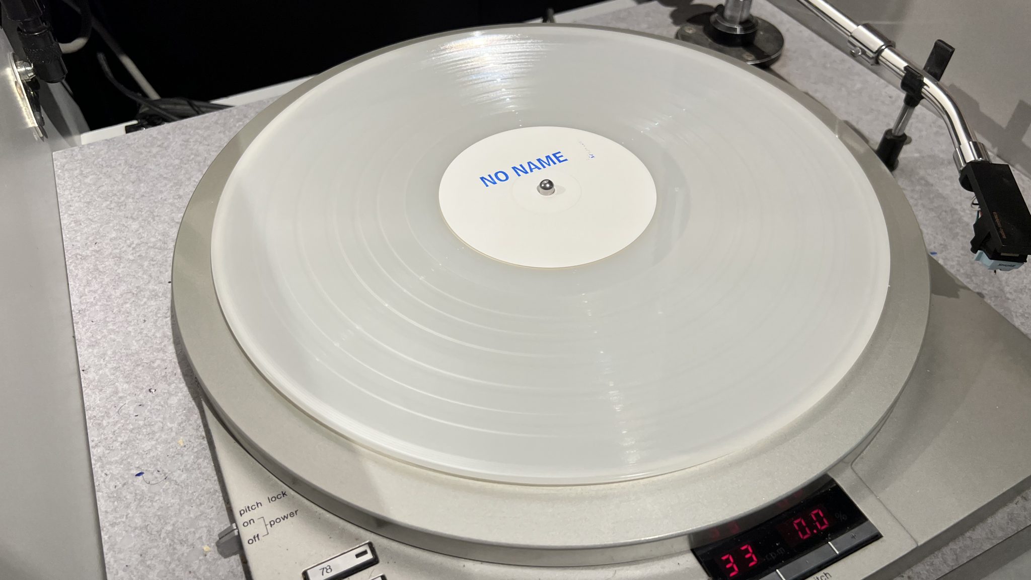 White vinyl record that says "no name" in blue letttering.