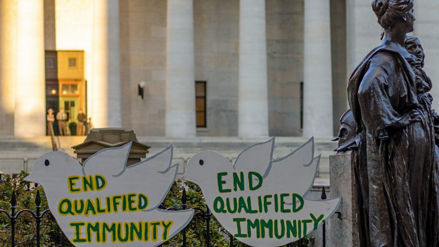 Two signs read "End qualified immunity" during a Black Lives Matter protest held outside the Ohio Supreme Court in Columbus, Ohio, July 2021.