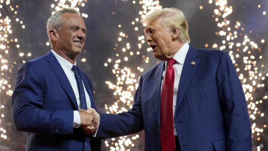 Republican presidential nominee former President Donald Trump shakes hands with Independent presidential candidate Robert F. Kennedy Jr. at a campaign rally at the Desert Diamond Arena, Friday, Aug. 23, 2024, in Glendale, Ariz.