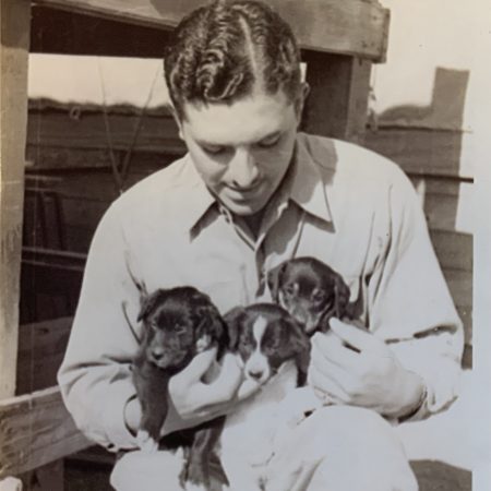 Thomas Mollicone poses with puppies.