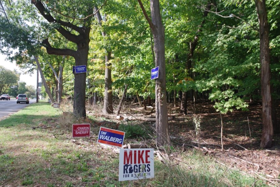 Signs advertising Republican presidential candidate Donald Trump sit stapled to trees on Howard Street in Kalamazoo.