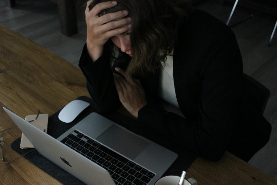 A stressed-out woman looks at a laptop