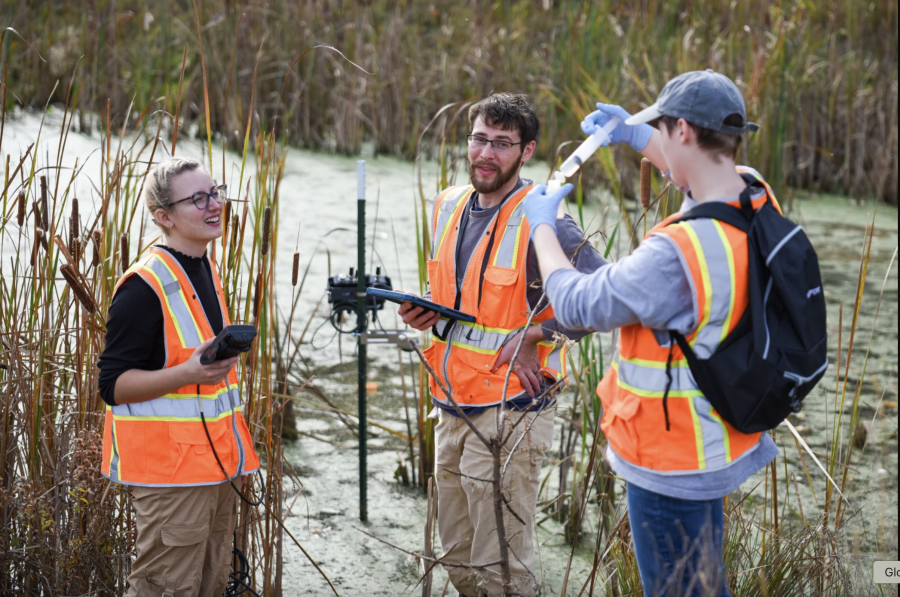 (From left) Alex Ochs, Connor Gluck, and Daiyanera Kelsey gather samples and download data at a wetland in Lorain, Ohio. The Martin's Run Wetland and Stream Restoration Project is one of 183 wetland projects in the state that are being monitored by the H2Ohio Wetland Monitoring Program.